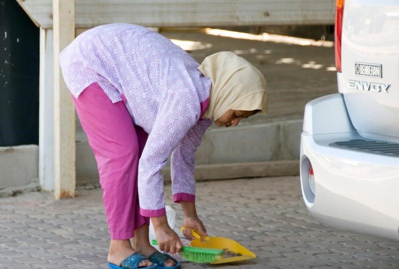 A maid sweeps in front of her employers’ house in Shamiya May 5, 2010. Kuwait, long criticised along with other oil-exporting Gulf states for its treatment of foreign workers, introduced a minimum monthly wage of 60 dinars ($209) in April in a move that affects hundreds of thousands of Asian labourers. But the new minimum wage, a first for Kuwait, has come under fire because it excludes roughly 560,000 domestic workers, prompting lawmakers to consider a separate law to set a minimum salary for maids and impose rules protecting them from abuse. Picture taken May 5.     REUTERS/Gayle St. Claire    (KUWAIT – Tags: EMPLOYMENT BUSINESS SOCIETY) – RTR2DUHA