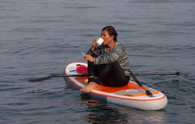 Indonesia’s Fisheries Minister Susi Pudjiastuti enjoying a cup of coffee and a cigarette on top of a paddleboard. Photo: Twitter/@susipudjiastuti