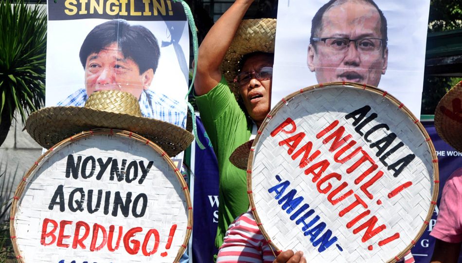 A protester throws a bag of paint at the photos of then President Aquino and then Agriculture Secretary Proceso Alcala during a rally at the DA office in Quezon City, April 2016. The demonstrators condemned the violent dispersal of Kidapawan farmers and criticized the government’s inaction in addressing their needs. PHOTO: ABS-CBN News/Manny Palmero