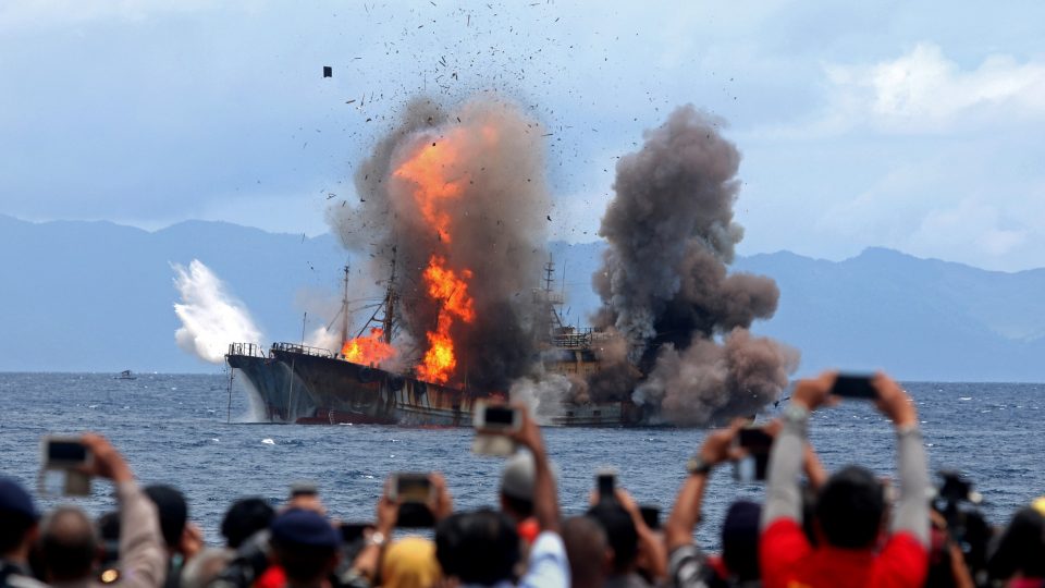 People take pictures of a burning ship as the government destroyed foreign boats that had been caught illegally fishing in Indonesia waters, at Morela village in Ambon island, April 1, 2017 in this photo taken by Antara Foto. Antara Foto/Izaac Mulyawan/via REUTERS
