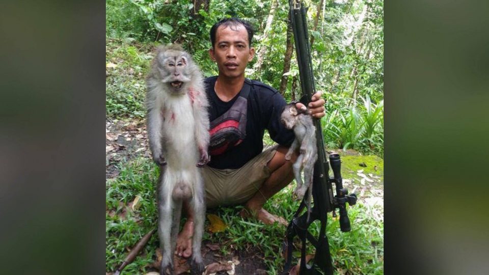 A photo posted to Facebook shows a man proudly posing with a large monkey and baby. 