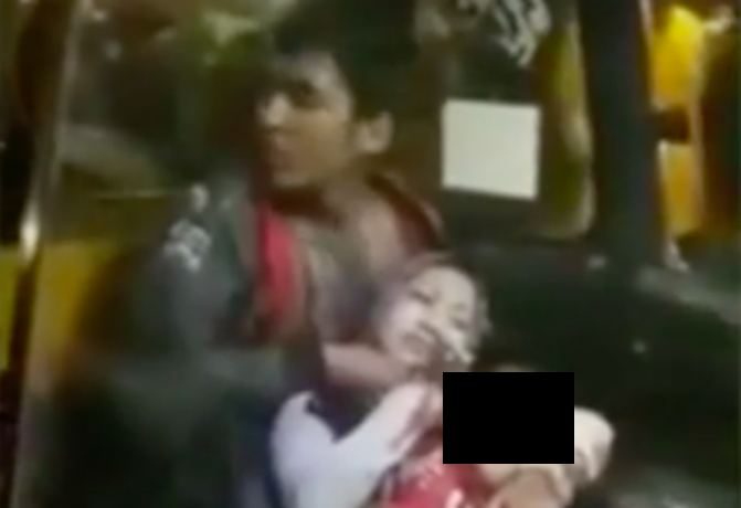 A mother and her baby being held hostage inside an angkot minivan in East Jakarta on Sunday, April 9. 2017. Photo: Video screengrab