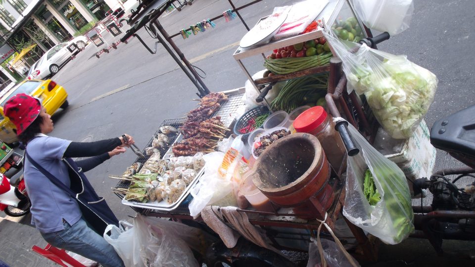 A vendor turns fish on a grill at a Bangkok street food stand in February 2010. 