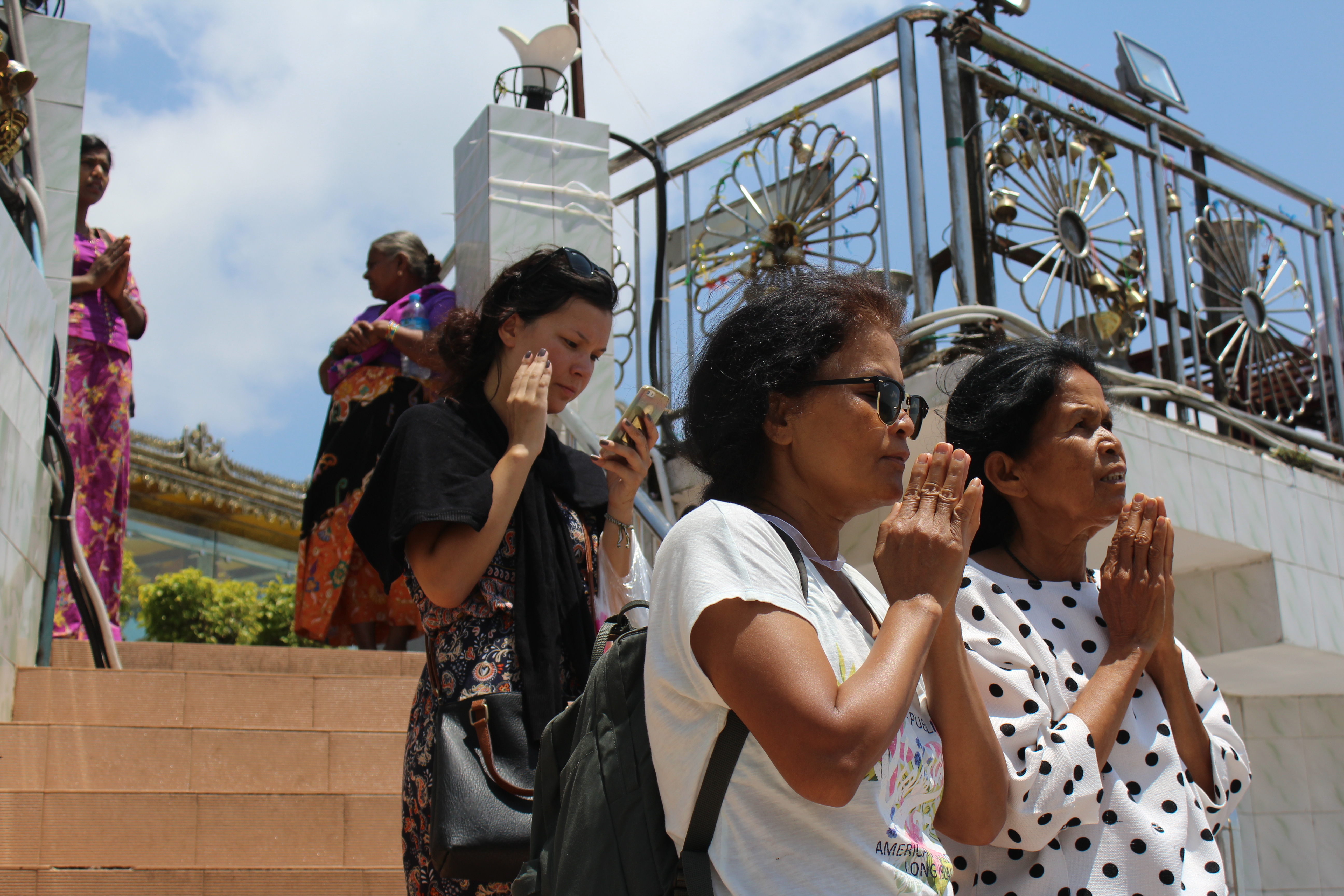 Aree (R) and Sanga pray toward the Golden Rock.