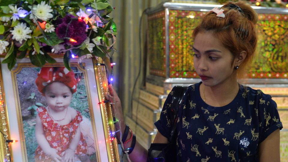 Jiranuch Trirat, mother of 11-month-old daughter, whose murder was broadcast on Facebook Live, stands next to a picture of her daughter at the funeral in Phuket, Thailand April 25, 2017. Photo: Sooppharoek Teepapan/ Reuters