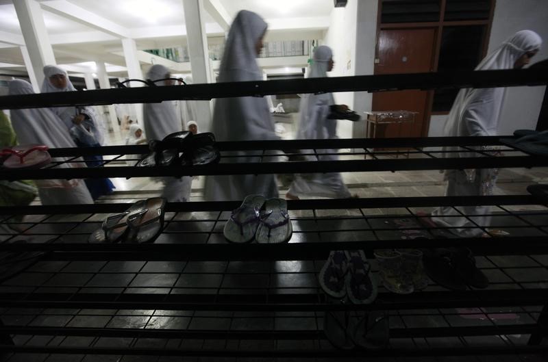 Students walk after prayer during the first day of the holy month of Ramadan at the Al-Mukmin Islamic boarding school in Solo, Indonesia Central Java province, August 1, 2011. The Al-Mukmin Islamic boarding school, founded by Indonesian cleric Abu Bakar Bashir in 1972, has 231 teachers and houses 1,503 students, both males and females, between the ages 12 to 18. Bashir was jailed for 15 years in June for helping plan a paramilitary group that aimed to kill the country’s president. According to Ibnu Hanifah, head academic at the boarding school, 300 new students enrol at the school annually and pay an enrolment fee of around 4 million rupiah ($470) and 500 thousand rupiah ($59) in school fees, which includes supplies of daily food for a month. Picture taken August 1, 2011. REUTERS/Beawiharta 