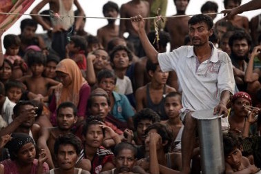 File picture taken on May 14, 2015 of Jamal, a 37 year old Rohingya migrant from Myanmar (in white shirt), standing amongst other Rohingya migrants from Myanmar and Bangladesh on a drifting boat in the Thai waters off the southern island of Koh Lipe in the Andaman. PHOTO: AFP/Christophe Archambault