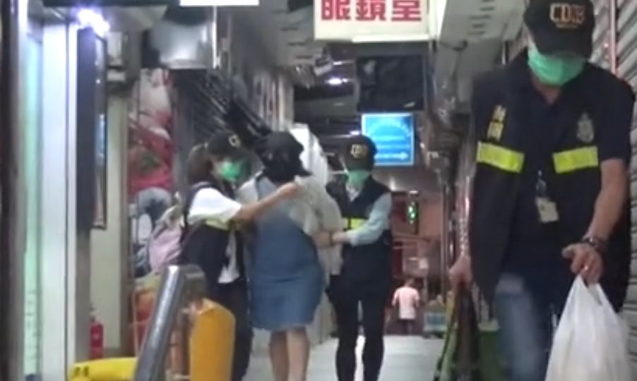 The suspect being led away by police officers. Screenshot: Oriental Daily