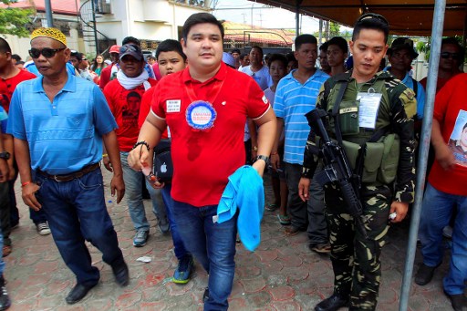 Shariff Aguak’s mayoral candidate Sajid Ampatuan walking escorted by supporters and bodyguards during a campaign rally in Shariff Aguak town, Maguindanao province, in the southern Philippine island of Mindanao.
Walking off stage after a rock star-like performance and rapturous crowd reaction, / AFP PHOTO /