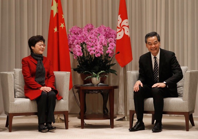 Hong Kong’s chief executive-elect Carrie Lam (L) and Chief Executive Leung Chun-ying smile during a press conference in Hong Kong on March 27, 2017, a day after Lam won the Hong Kong chief executive election.  AFP PHOTO / POOL / Vincent Yu