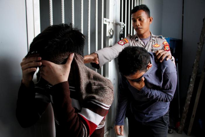 ILLEGAL TO BE GAY: In this file photo from May 2017, two Indonesian men, who were later sentenced to 85 lashes of the cane for having sex together, are escorted by police into an Islamic court in Banda Aceh, Aceh province, Indonesia May 17, 2017. REUTERS/Junaidi Hanafiah/