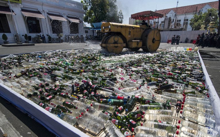 Indonesian authorities destroy thousands of bottles of alcohol ahead of the holy month of Ramadan at a police station in Surabaya, eastern Java island, on May 24, 2017.
Indonesia, the world’s most populous Muslim-majority country, will start Ramadan on May 27. / AFP PHOTO / JUNI KRISWANTO